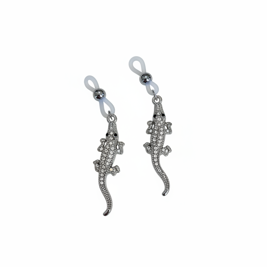 Zilveren hagedis tepelhangers met kristallen en blauwe kralen op witte achtergrond
