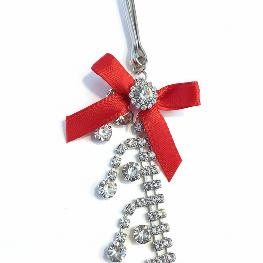 Kristallen ketting tepelklemmen - close-up detail van witte strass en rood strikje