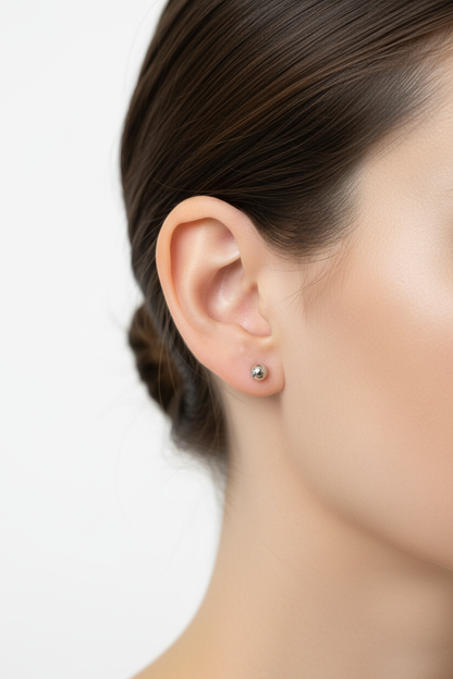 Kleine ronde zilveren balletjes oorbel op model