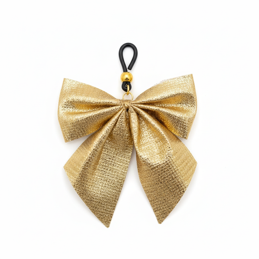 Gouden strik tepelhanger close-up - detail van metallic stof en zwarte clip